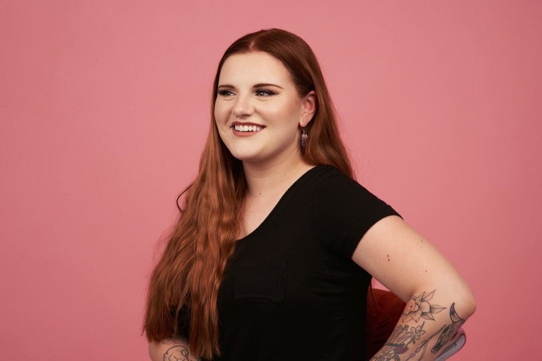 Woman taking photos against pink background